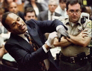 O.J. Simpson smiles to the camera as he tries to take out the guard that blocks his way out of the coutroom.